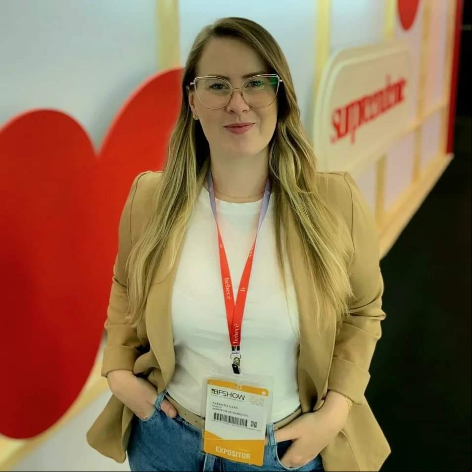 Mulher loira usa óculos e veste blazer caramelo